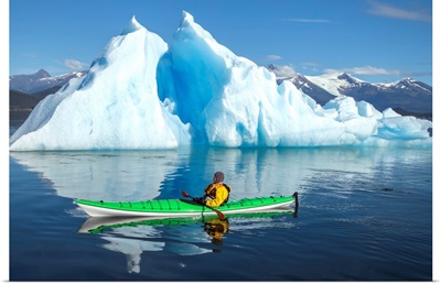 Sea Kayaker Paddles Beside An Iceberg, Alaska
