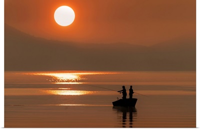 Silhouetted Anglers Standing In A Boat Fishing For Salmon At Sunset, Juneau, Alaska