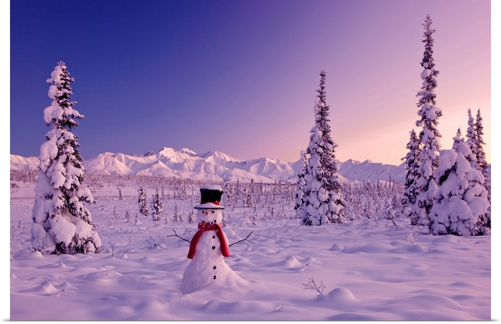 Large canvas photo of a snowman sitting in a snowy landscape with mountains in the distance and snow covered trees surroun...