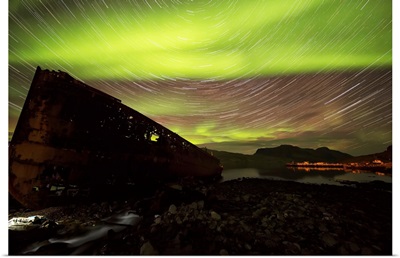 Star trails and northern lights over top the town of Djupavik, Iceland