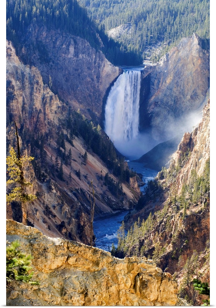 Sunlit sulphuric rock of the cliffs surrounding the Lower Falls of the Yellowstone River in the Grand Canyon of the Yellow...