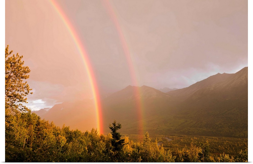 A double rainbow from a passing summer evening storm in Eagle River Valley is illuminated by the setting sun in Southcentr...
