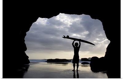 Surfer Inside A Cave At Muriwai, North Island, New Zealand