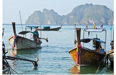 Thailand, Koh Phi Phi, Longtail boats along the shoreline, Mountains in distance