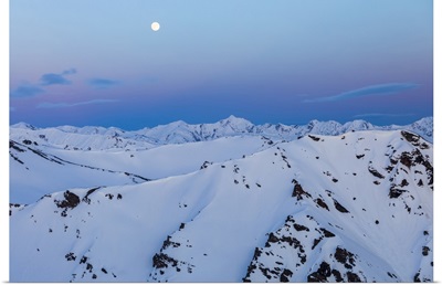 The Moon Rises Over Snowy Mountain Ridges After Sunset In The Alaska Range, Alaska