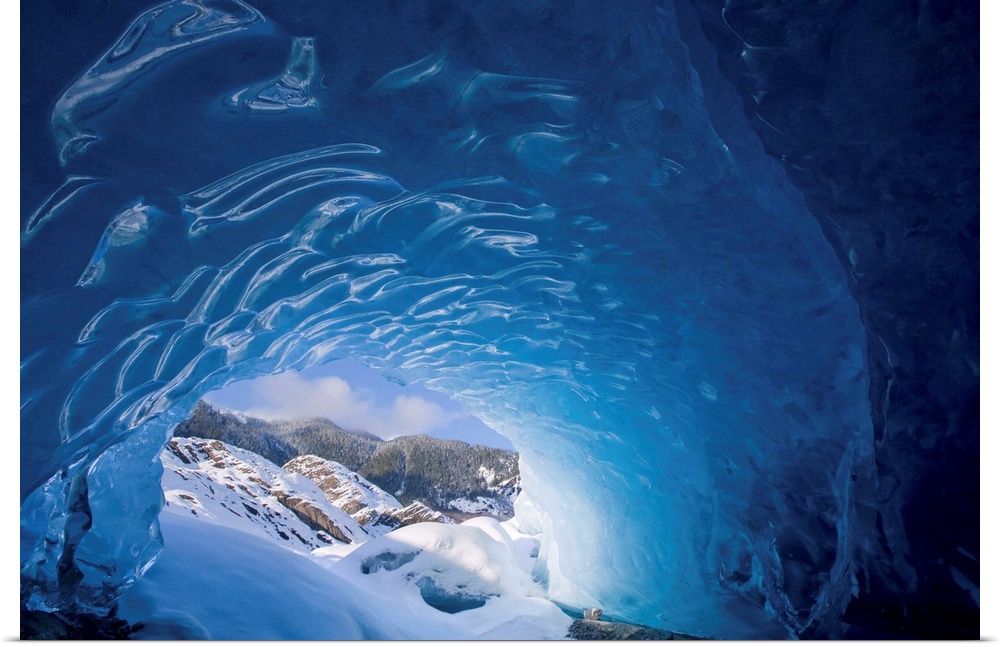 View from inside an ice cave looking outward at the snowcovered landscape