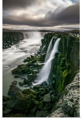 Waterfall flowing over moss covered cliffs; Selfoss, Iceland