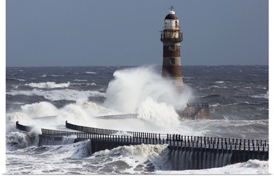 Waves crashing into a lighthouse on the coast, Sunderland Tyne and Wear England