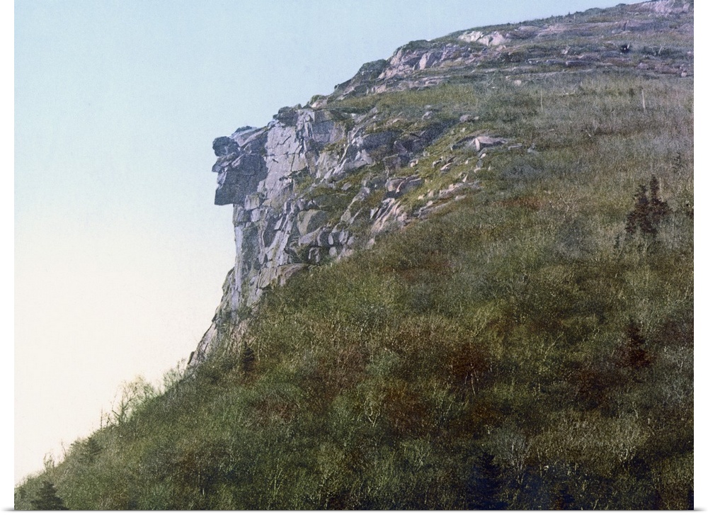 Photo on canvas of the face of a man made out of rocks hanging on a cliff of a mountain.