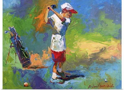 A young boy swinging at the golf ball