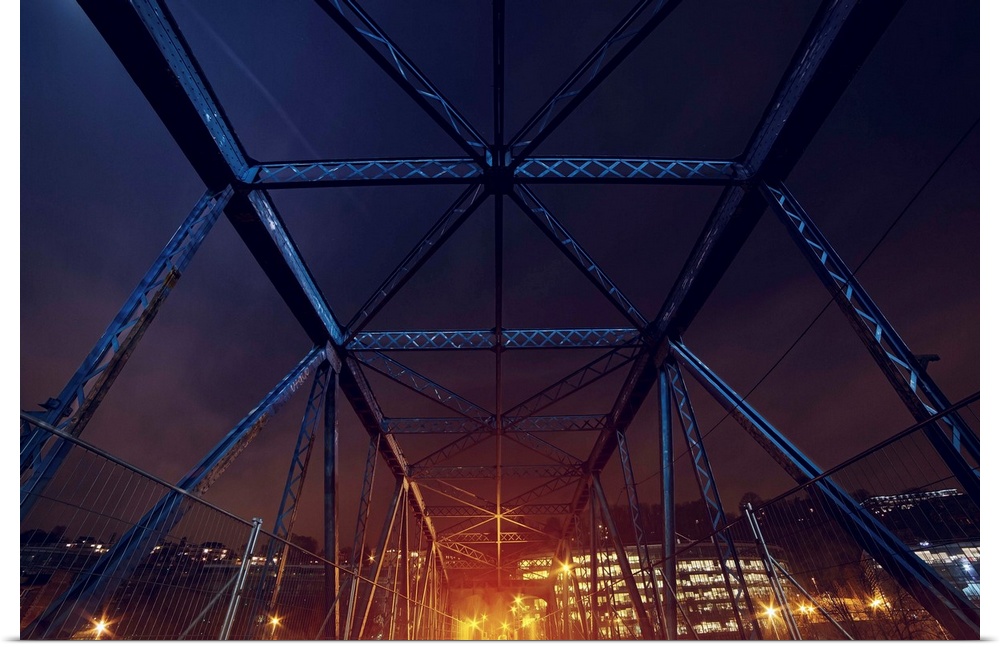 An HDR photograph of an urban area seen through the frame of a bridge.