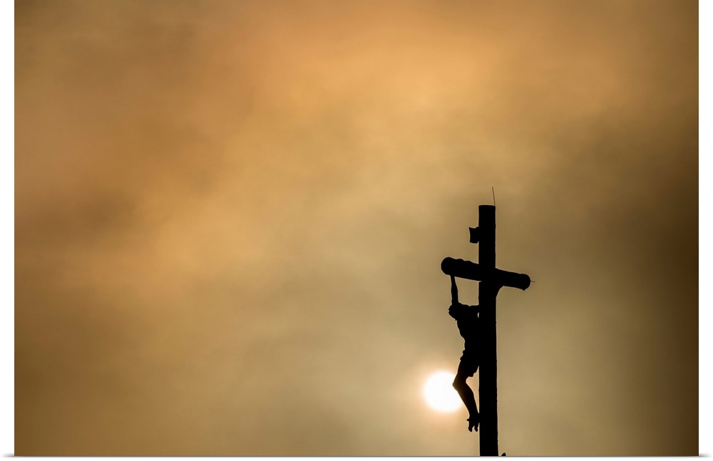 Silhouette of Christ on the cross at sunset.