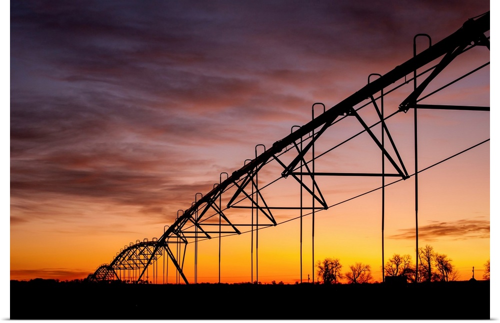 Beautiful sunset photograph with a silhouette of a farms irrigation system.