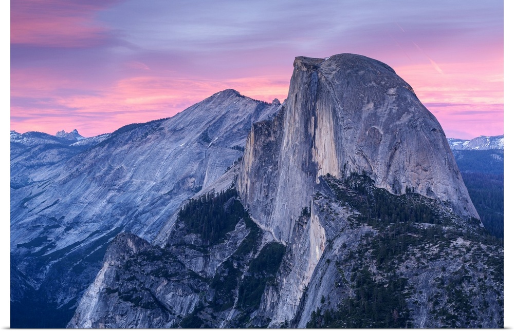 Half Dome in Yosemite with pink clouds in the sky.