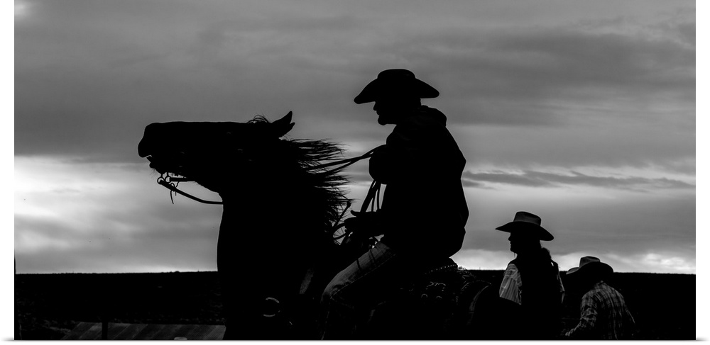 Black and white silhouette photograph of a cowboy on horseback.