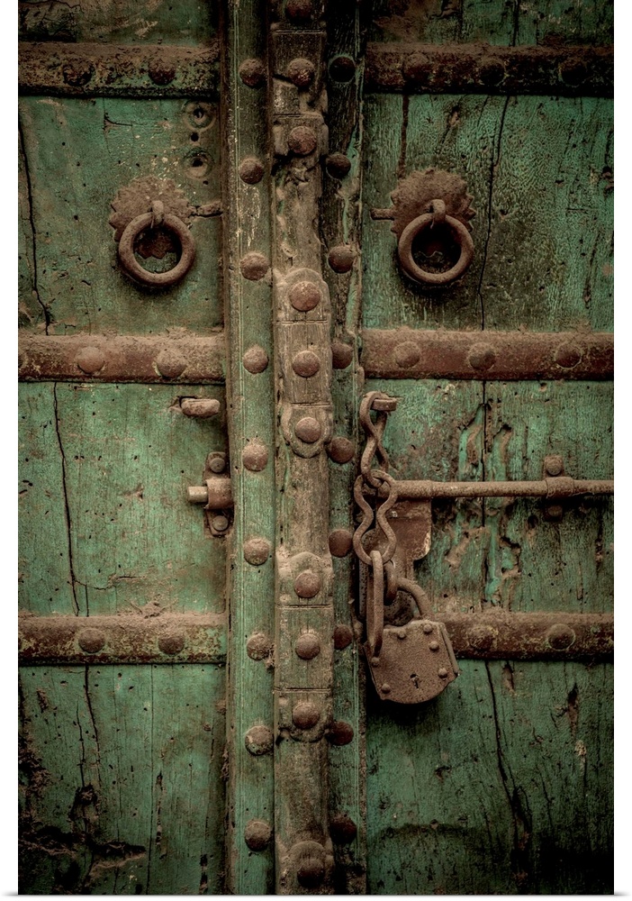 Photograph of an old antique door with a large chain lock and bolts.
