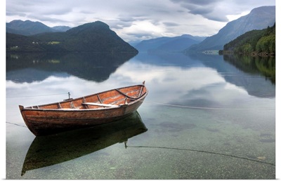 Red rowing boat on a still lake, Norway