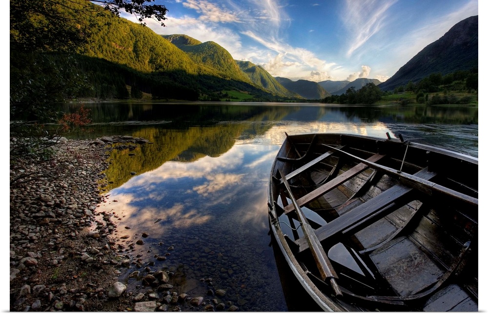 Row boat resting on the shore with mountains in the background