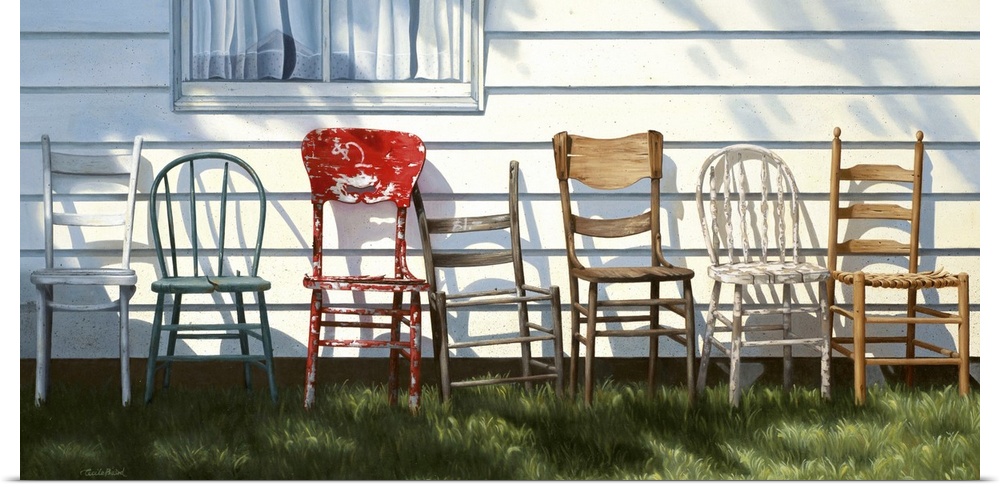 Row of wooden chairs lined up in front of a house.
