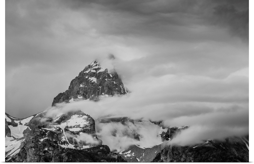 Black and white photograph of a cloudy mountain peak.