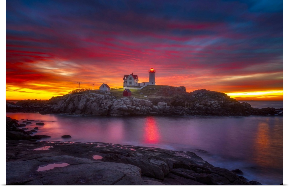 A vibrant sunset over Cape Neddick Lighthouse in York, Maine.