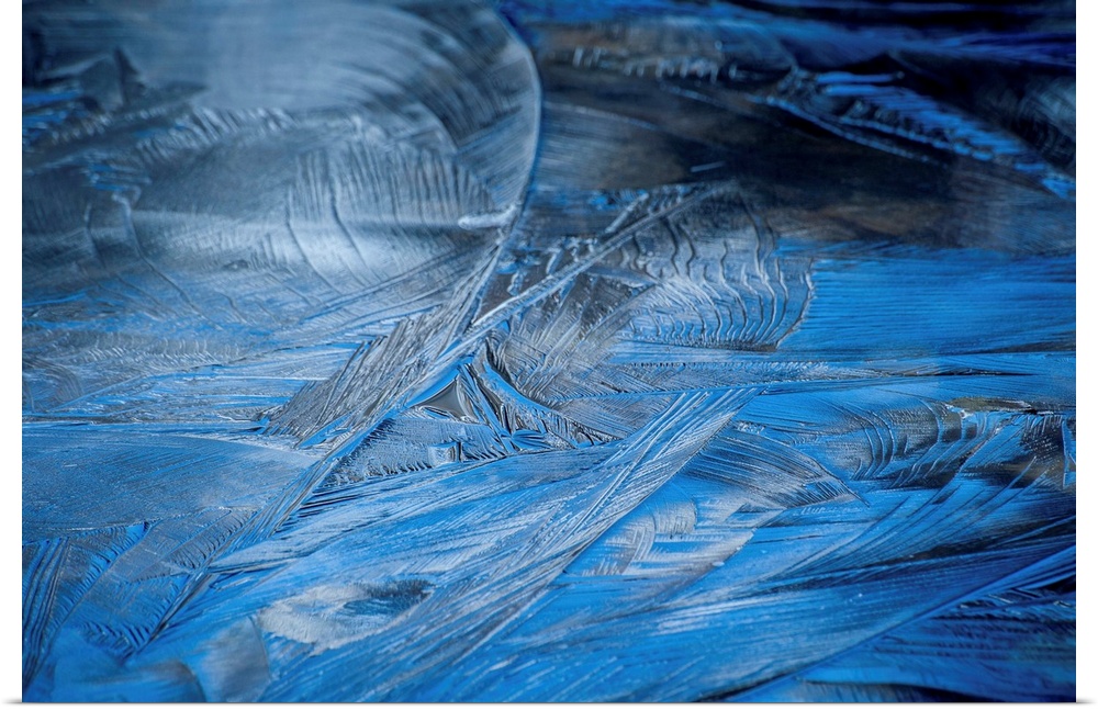 Close-up abstract photograph of the texture from frozen water in shades of blue.
