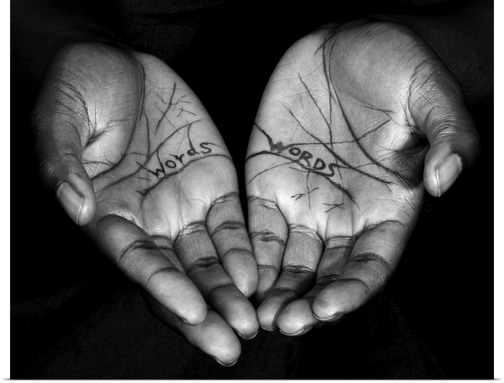 A high impact contemporary black and white photograph of a pair of hands feadruing the words 'words' inscribed on them