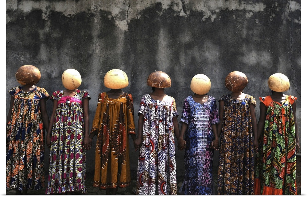 A high-impact fine art photograph of a group of women wearing stitched calabash gourds on their heads. These gourds are ne...