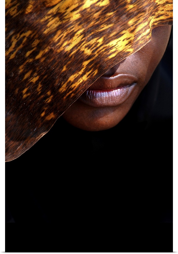 A contemporary fine art photograph of the lower part of a woman's face, the rest of which is hidden behind a textured gold...