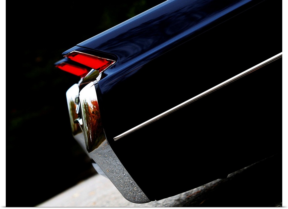 Angled photograph of the rear side of a 64 Cadillac Coupe de Ville 3 with red break lights.