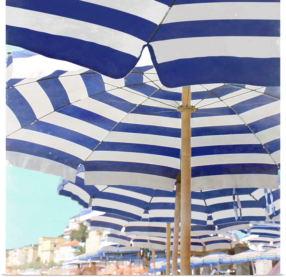 Square decor with blue and white striped beach umbrellas lined up on the beach.