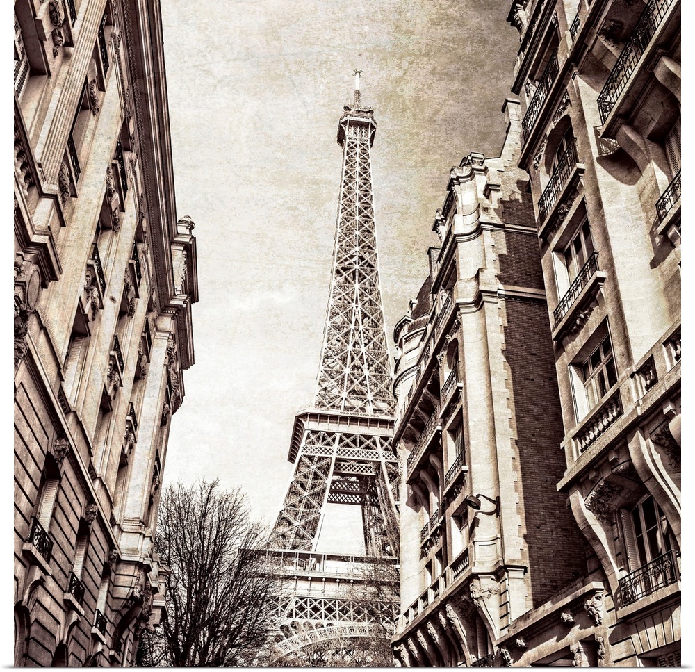 A square photo of the Eiffel Tower from the street in a sepia tone and a textured effect overlay.