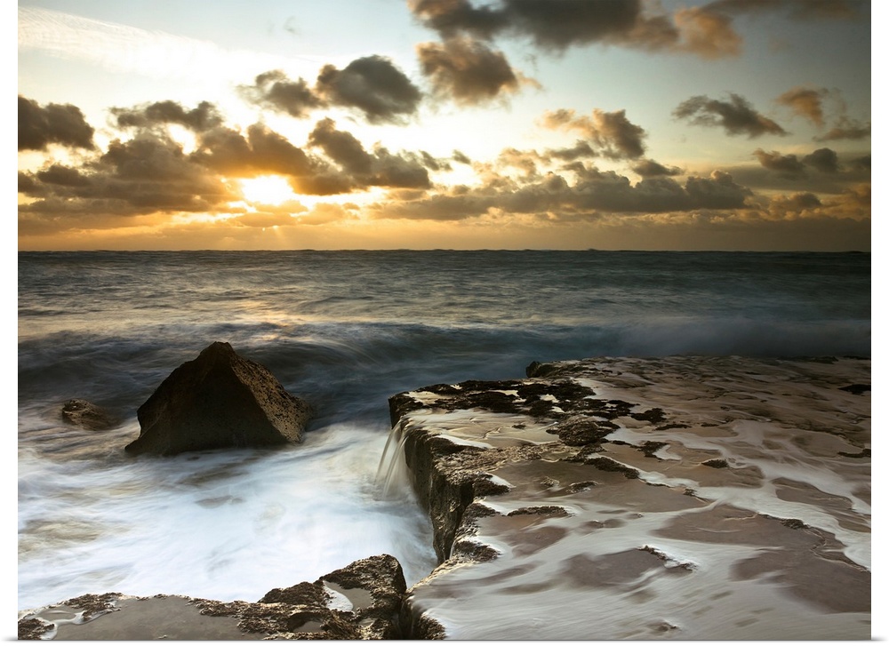 Image of a rocky coastline during a cloudy sunset.