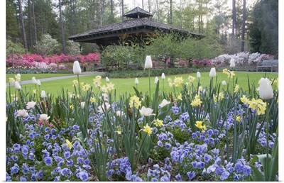 A covered pavilion in a garden of spring flowers