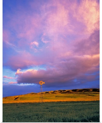 A windmill is dwarfed by enormous violet clouds in Ventura County, California