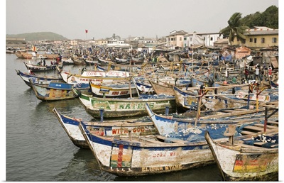 Africa, Ghana, Elmina. Colorful hand-painted fishing boats tied up at Elmina port