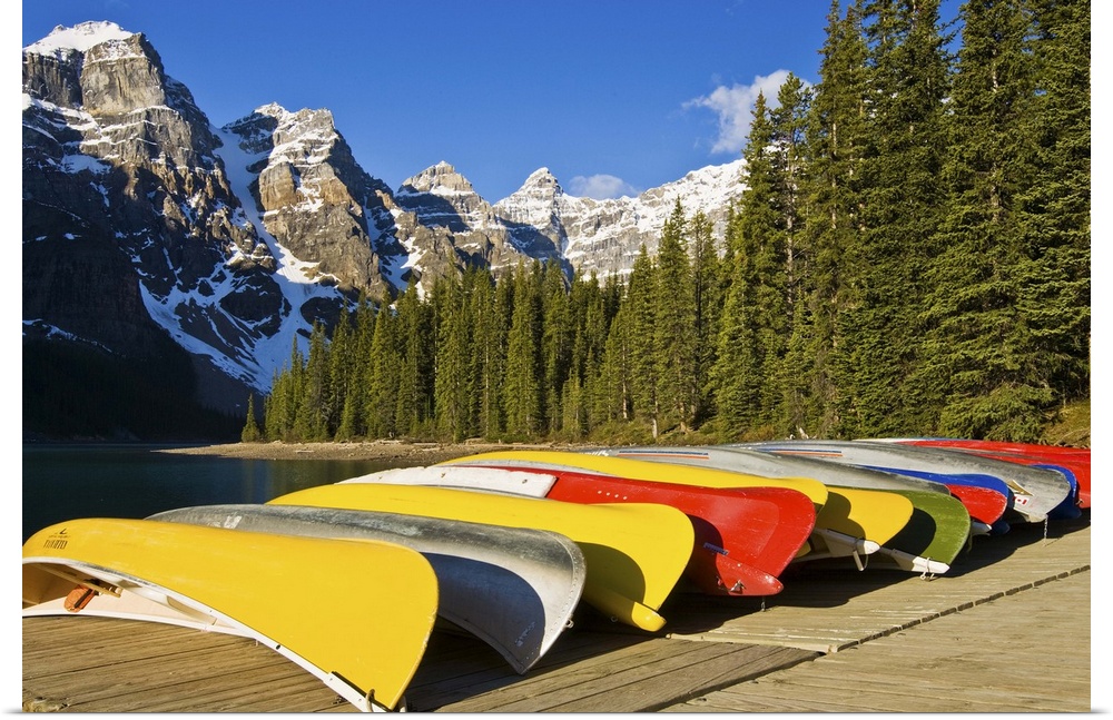 North America, Canada, Alberta, Banff National Park, Moraine Lake and rental canoes stacked on shore