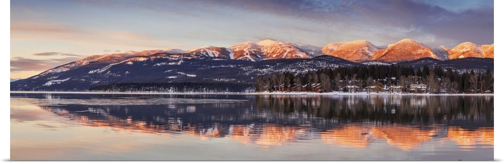 Panoramic of Big Mountain reflects into Whitefish Lake at sunset in winter in Whitefish, Montana, USA