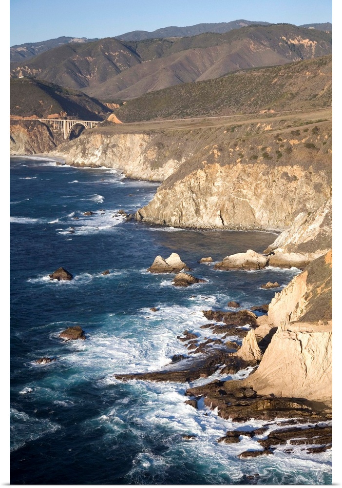 California, Big Sur. Ragged and rough cliffs drop down to the sweeping coastline on Highway 1, Bixby bridge in the distance.
