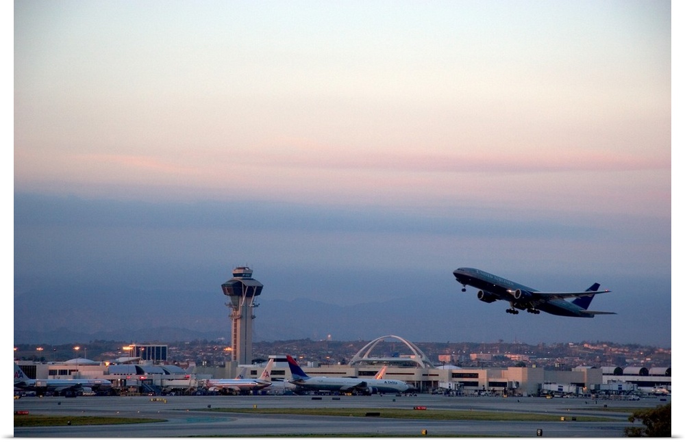 Boeing 767 airplane taking off at LAX airport, Los Angeles, California at dusk.