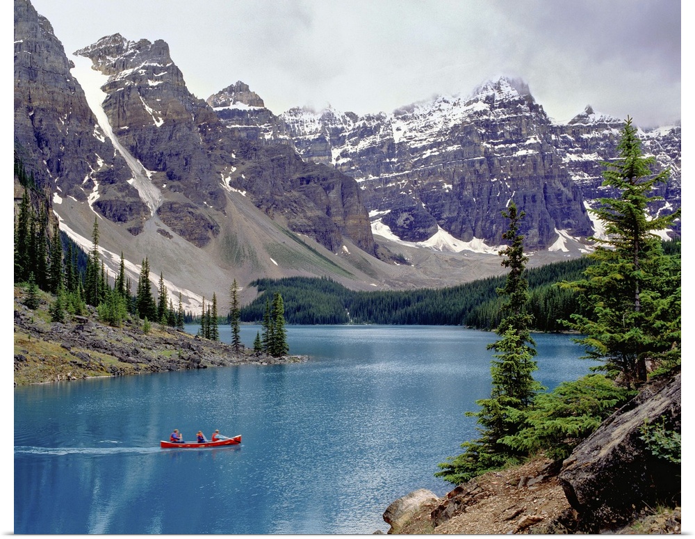Canada, Alberta, Moraine Lake. A canoe glides across beautiful Moraine Lake in the Valley of the Ten Peaks, Banff NP, a Wo...