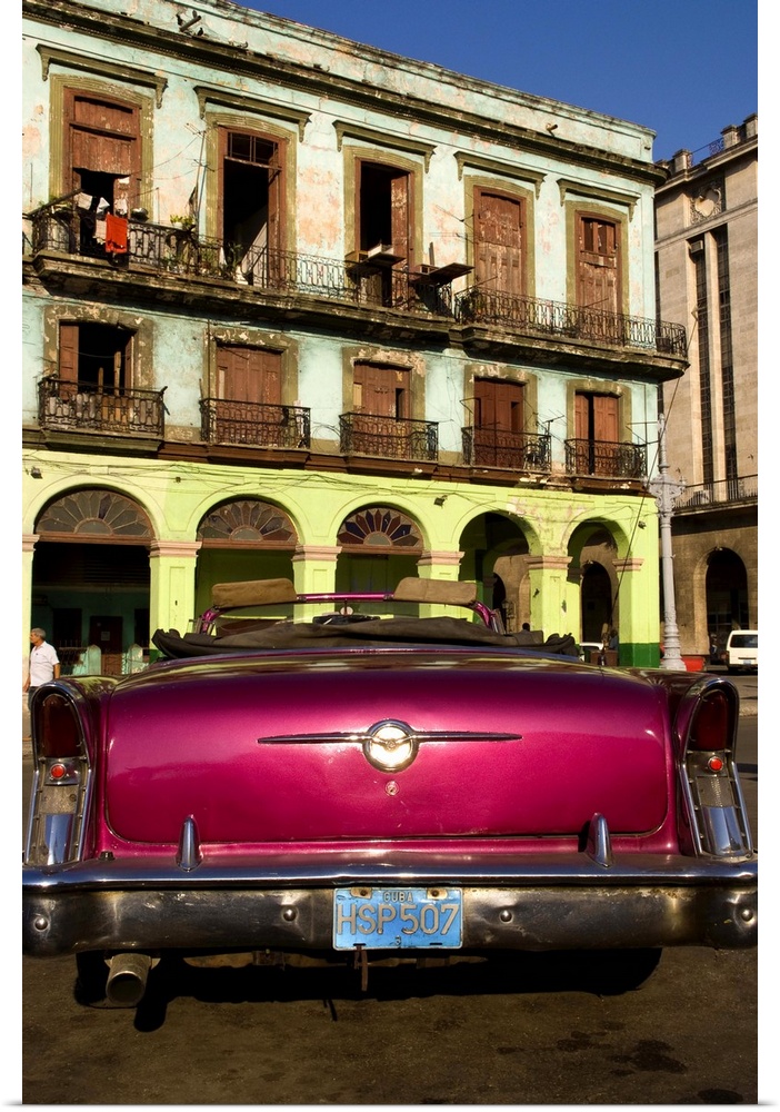 Classic 50s Buick colorful convertible auto in Havana Cuba Habana in front of old worn and colorful apartment buildings in...