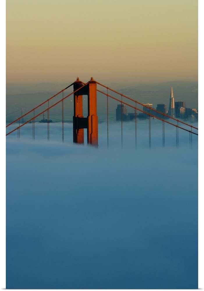 Fog rolls through the San Francisco bay covering the Golden Gate Bridge and city. Pictured is the top of the Golden Gate B...