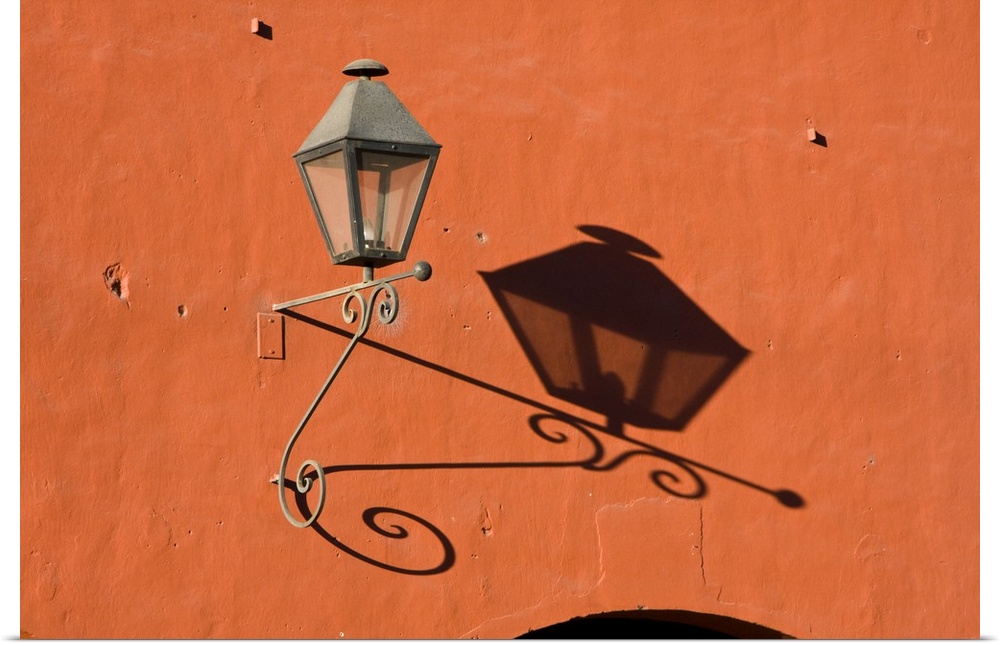 Central America, Guatemala, Antigua.  A lantern with shadow on a colorful wall in the town of Antigua.