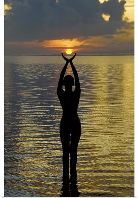 Indonesia, Bali. Woman silhouetted at sunrise on Sanur Beach