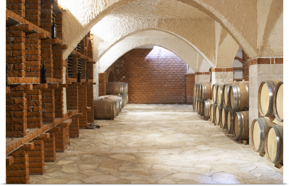 Wine cellar with bottle bins and oak barrels, arched vaulted ceiling. Matusko Winery. Potmje village, Dingac wine region, ...