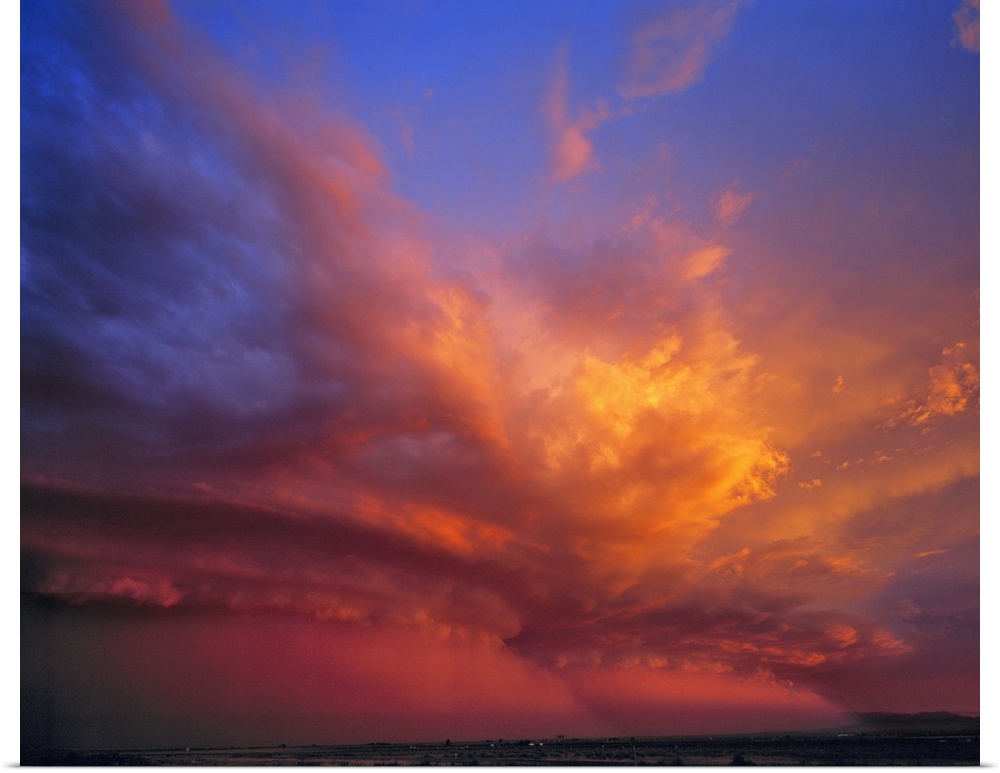 USA, Nevada. Storm clouds color with the setting sun over the Nevada desert.