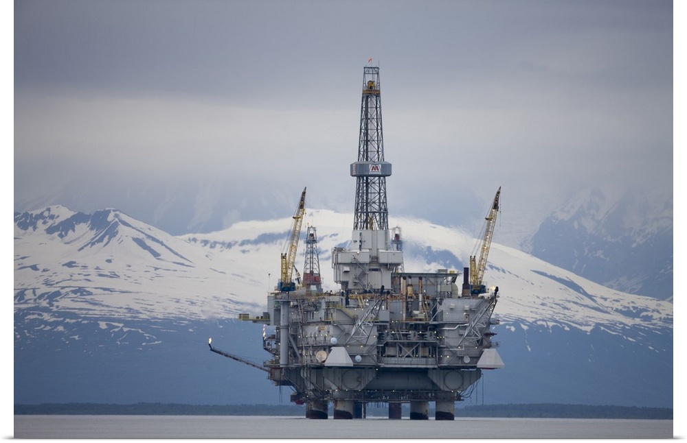 USA, Alaska. Offshore oil drilling rig in Cook Inlet and distant Alaska Range peaks on summer evening.