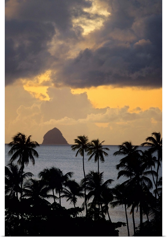 The sun sets behind Diamond Rock viewed from the island of Martinique in the Caribbean Sea.