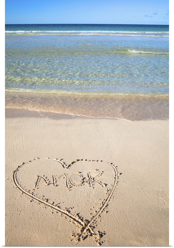 Vieques, Puerto Rico - A heart is drawn in the sand of a beach with the word 'amor' inside. Vertical shot.
